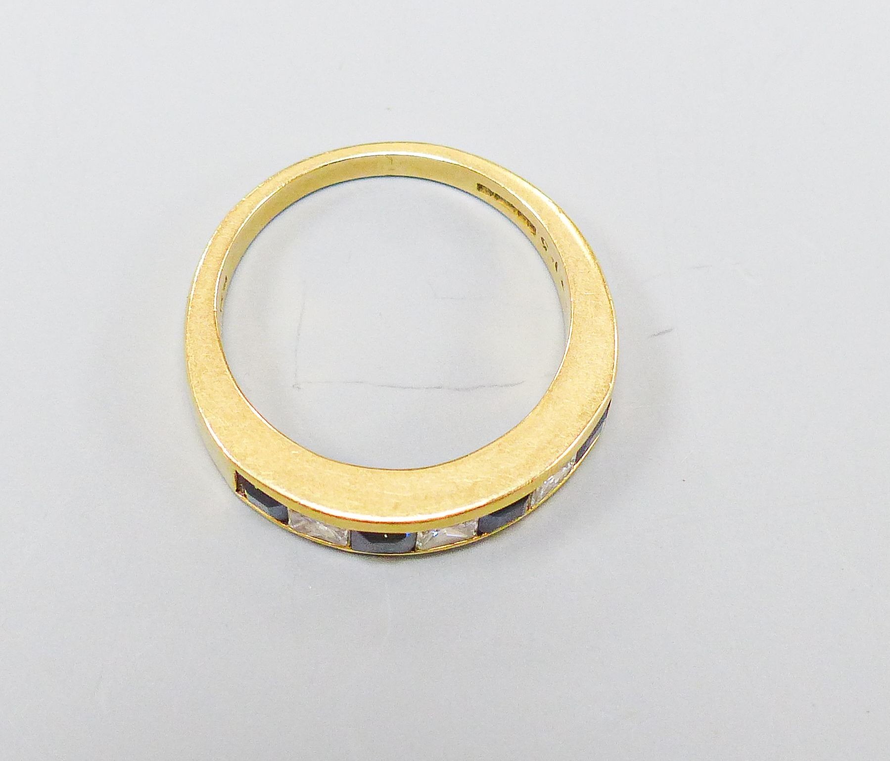 A modern 18ct gold, four stone sapphire and three stone diamond set half hoop ring, size P, gross weight 6.1 grams.